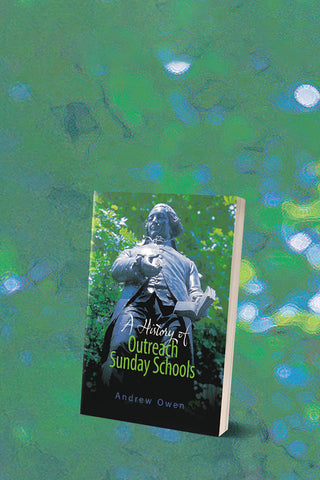 Slide showing a copy of the book A History of Outreach Sunday Schools against a background of green foliage which is out of focus.